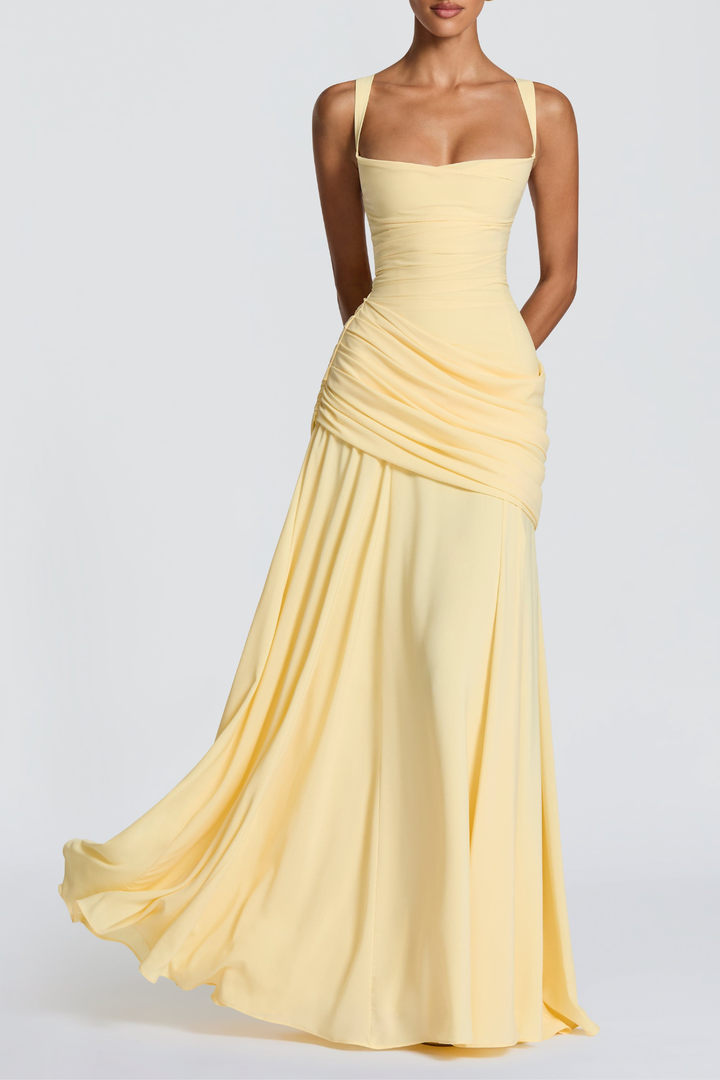 Editorial styling image of a pale-yellow ruched floor-length dress